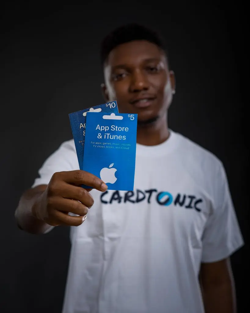 An image of a man holding gift cards.