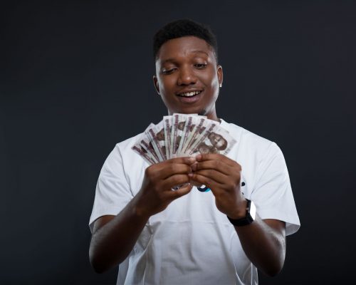 An image of a man smiling with cash. happy.