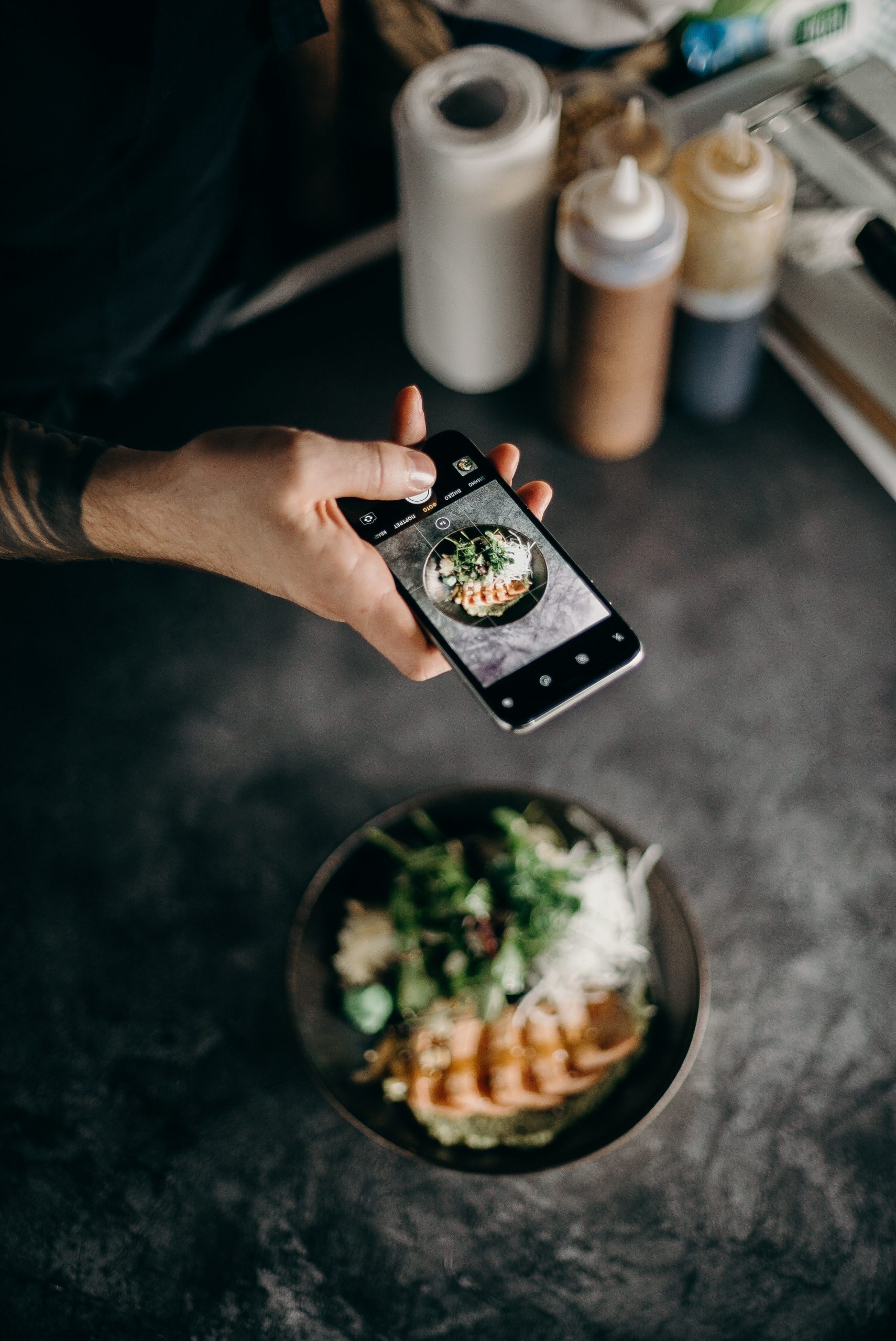 An image of an influencer taking a picture of his food