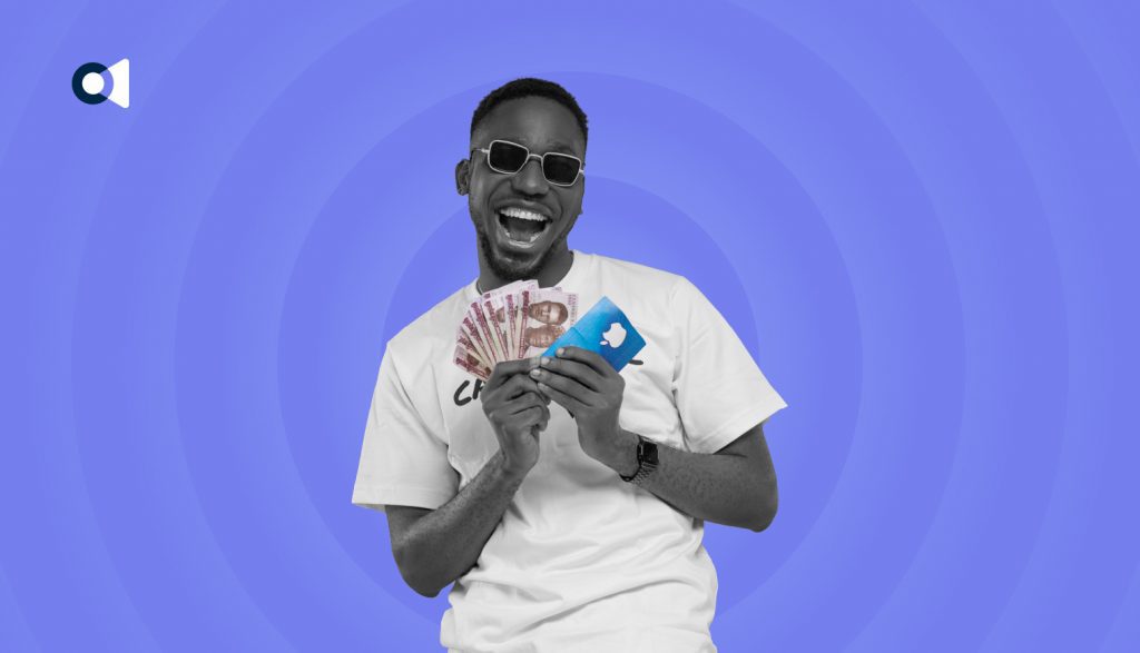 An image of a man holding both gift card and cash.